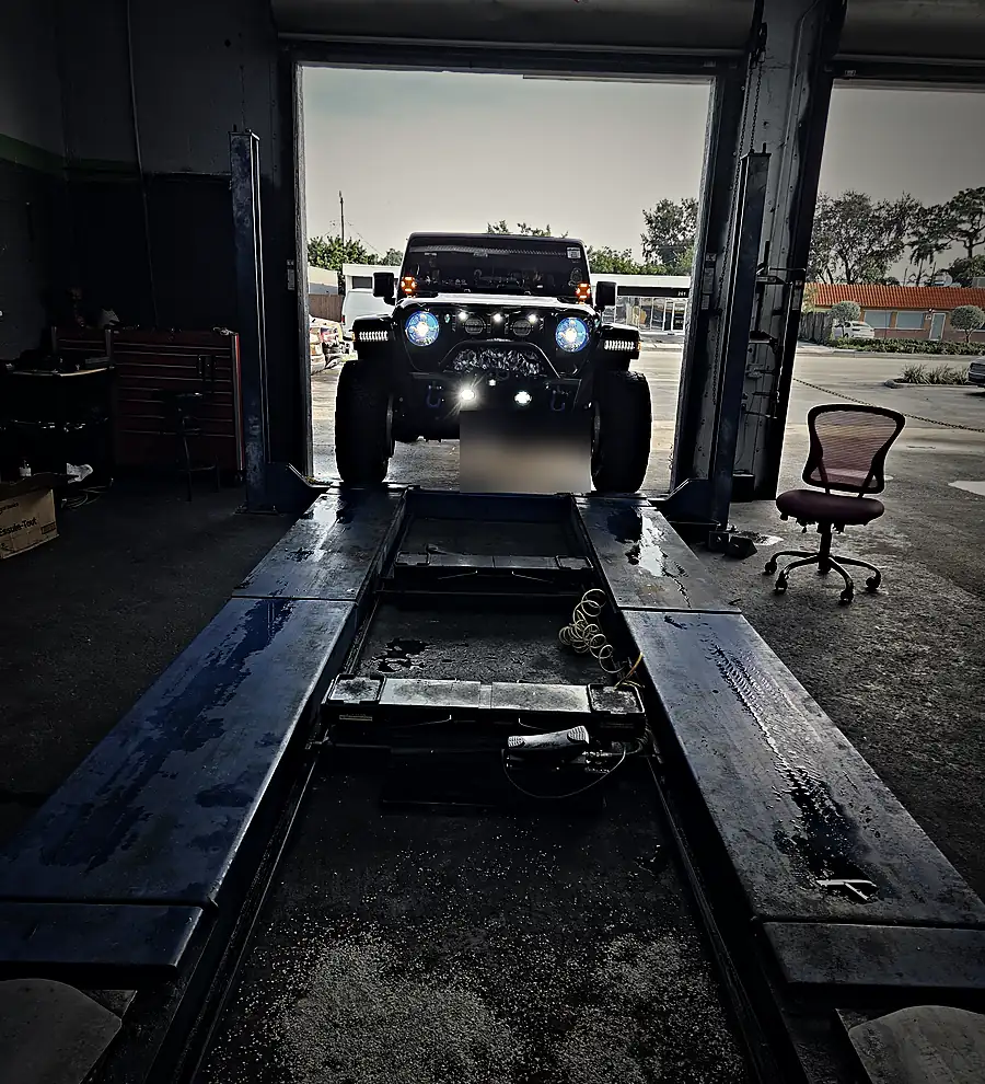 Jeep subiendo a la rampa de alineación en el taller Prestige