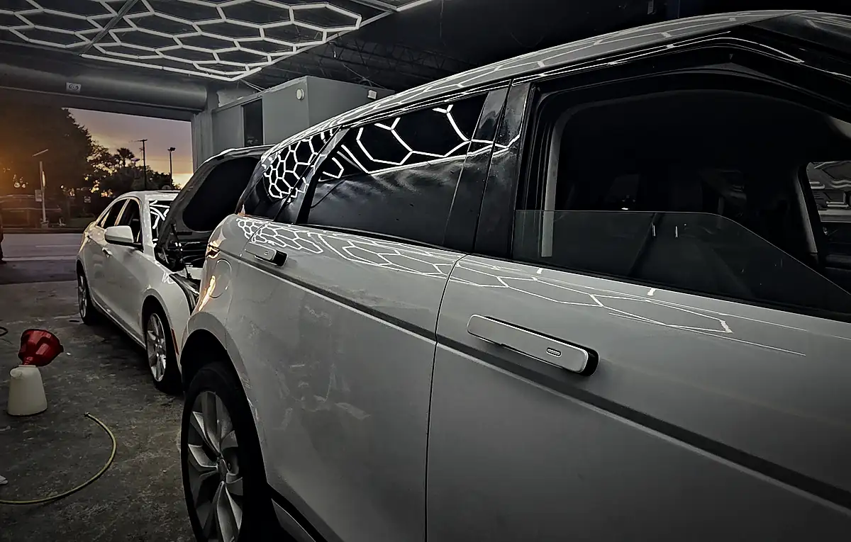 White Range Rover Evoque parked in a Prestige service bay, side view