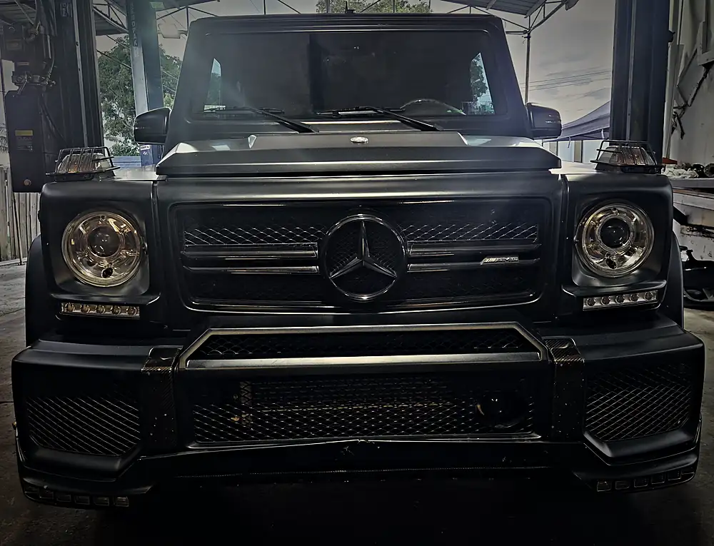 Matte black Mercedes-AMG G-Class, front view, in the service bay