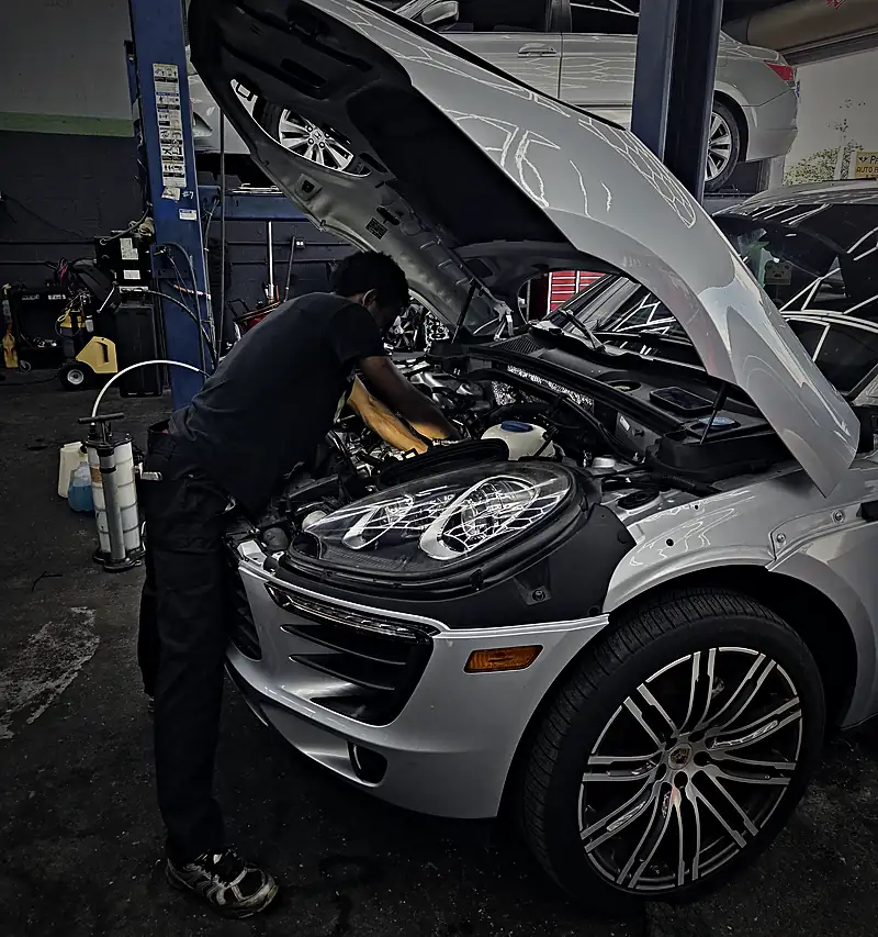 Technician servicing a Porsche Macan engine