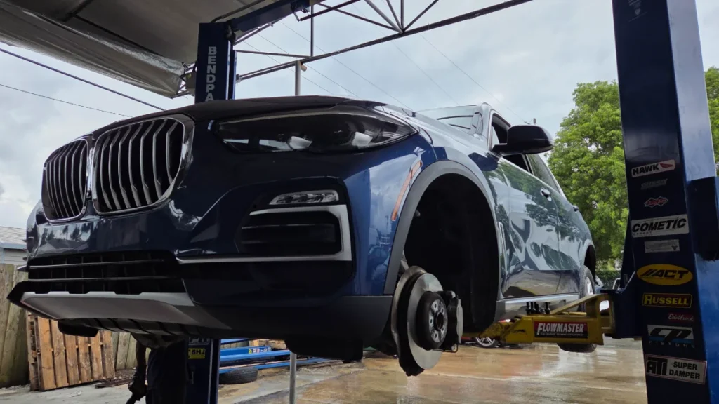 BMW X5 on the lift for repair at Prestige Auto Repairs & Tires, serving Coral Springs